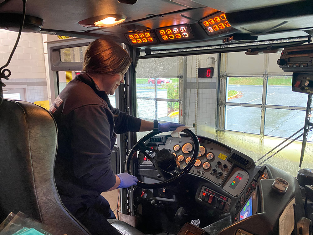 female firefighter cleaning steering wheel of cab